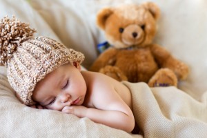 Little baby boy sleeping with teddy bear